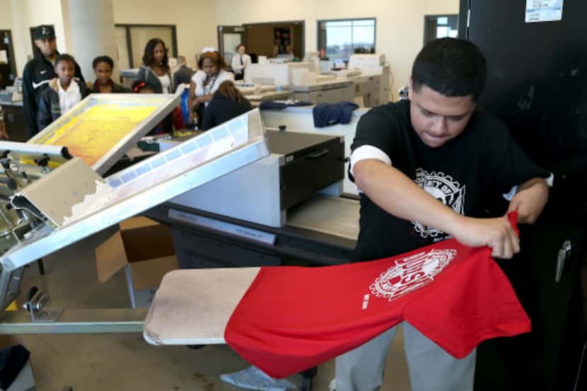Graphic Arts student Juan Villarreal makes a screen print T-shirt being given away at...
