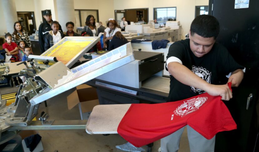 Graphic Arts student Juan Villarreal makes a screen print T-shirt being given away at...