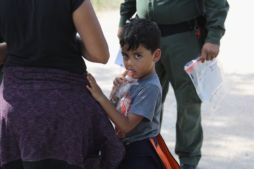Central American asylum seekers wait as Border Patrol agents take them into custody on June...