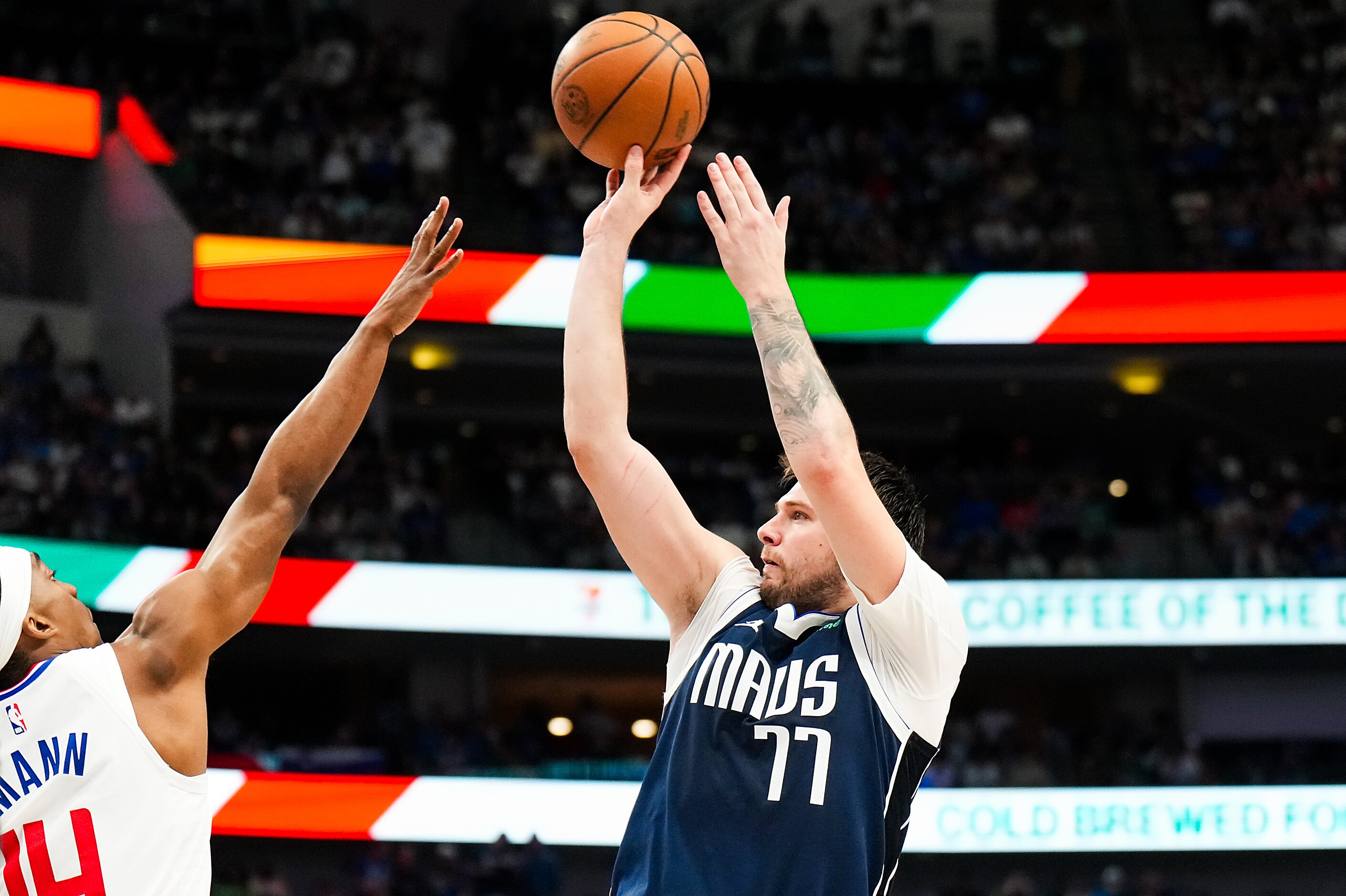 Dallas Mavericks guard Luka Doncic (77) shoots a three-pointer over LA Clippers guard...