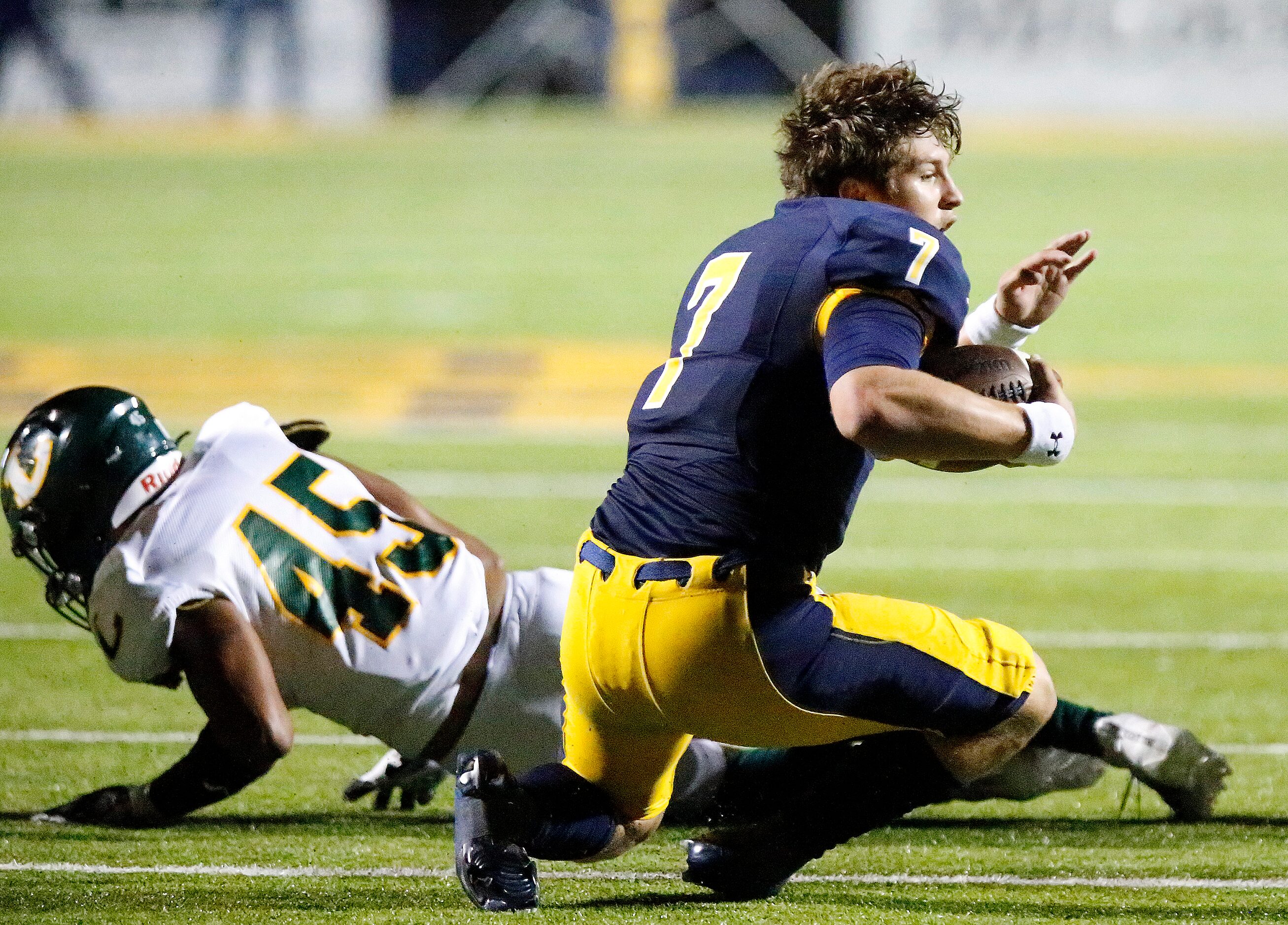 Highland Park High School quarterback Brennan Storer (7) looses his helmet after a hit by...