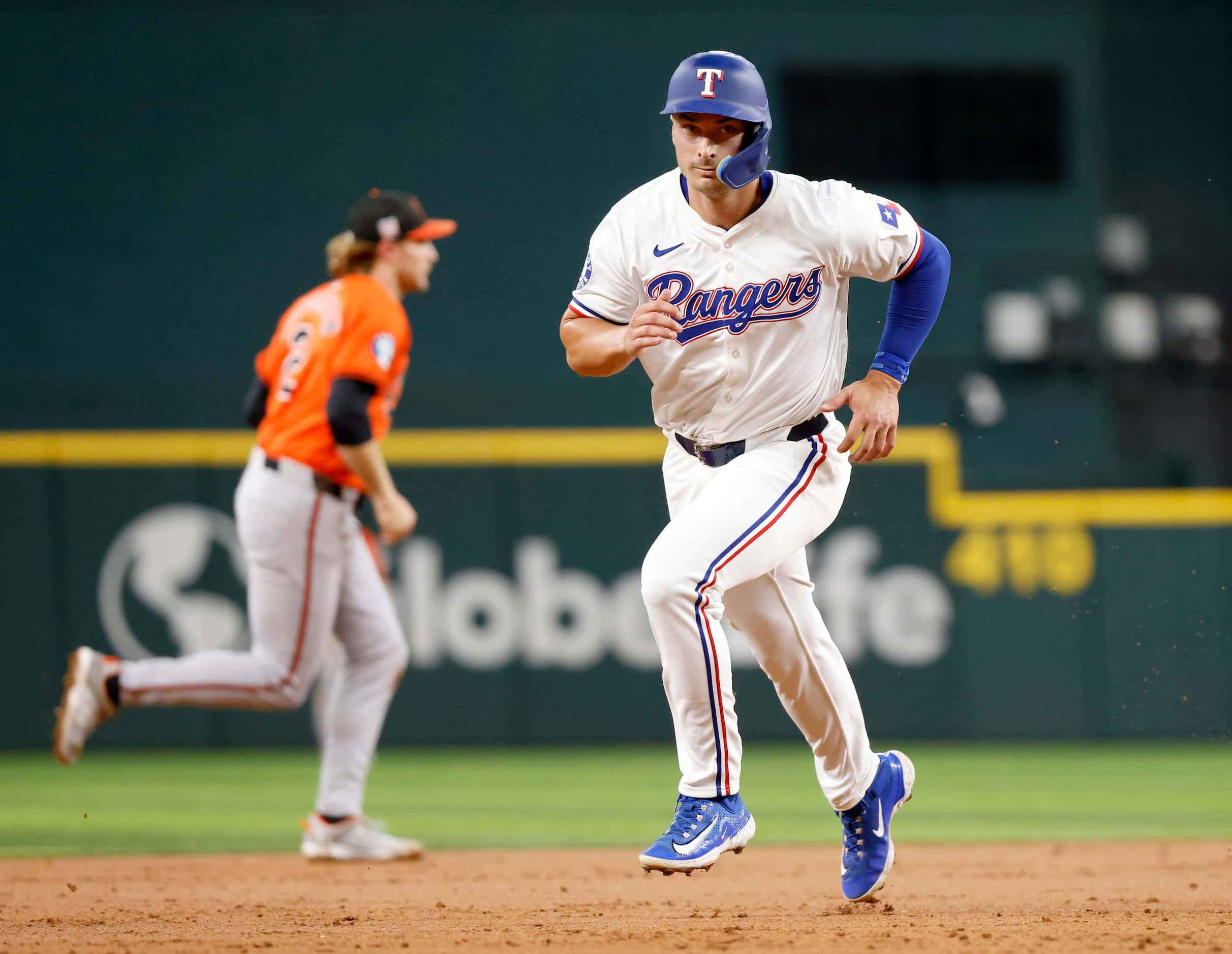 Texas Rangers designated hitter Justin Foscue races toward third before scoring on a Andrew...
