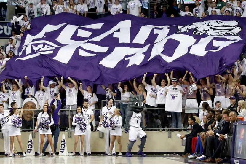 TCU fans hold up a giant flag that reads, "Fear The Frog", behind the Kansas bench, bottom...