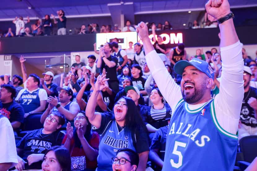 Dallas Mavericks fan Ernest Perez (right) with others cheer followed by a point in the first...