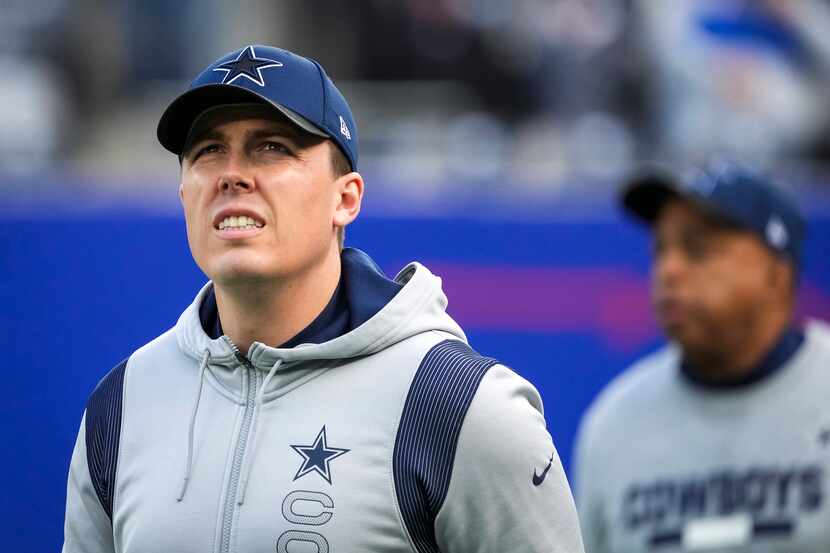Dallas Cowboys offensive coordinator Kellen Moore takes the field before an NFL football...