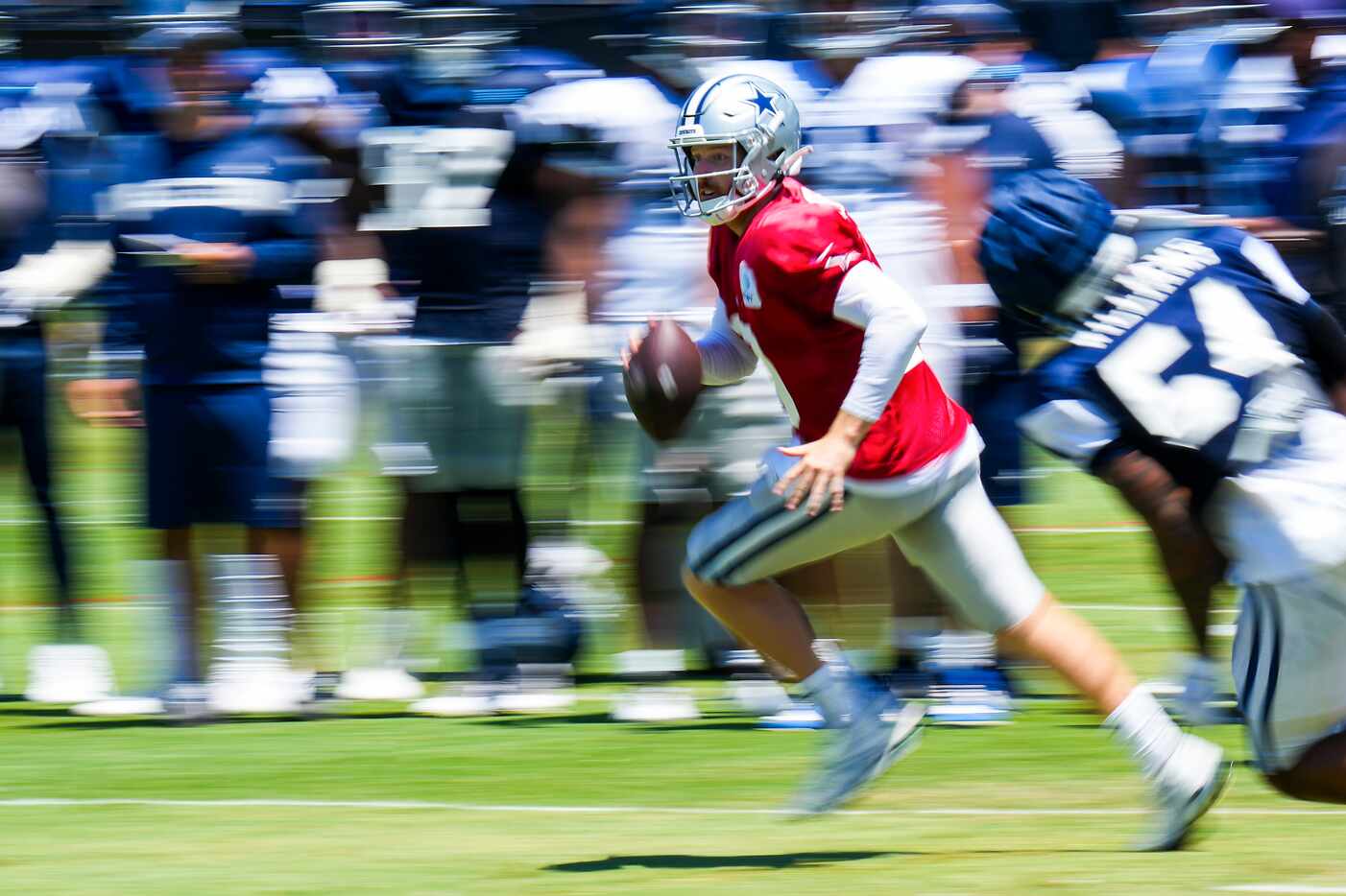 Dallas Cowboys quarterback Cooper Rush (10) scrambles away from defensive end Sam Williams...