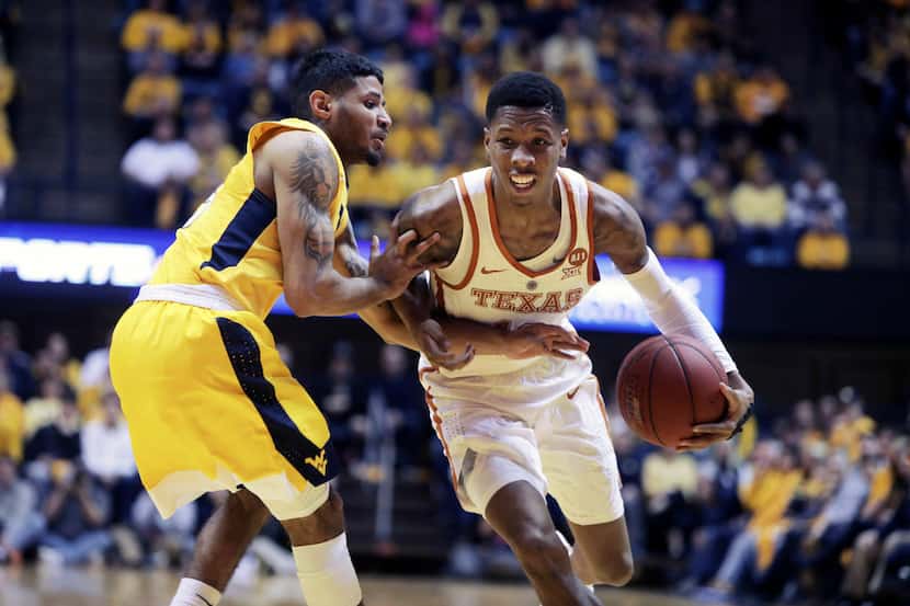 Texas guard Kerwin Roach II (12) drives while being defended by West Virginia guard James...