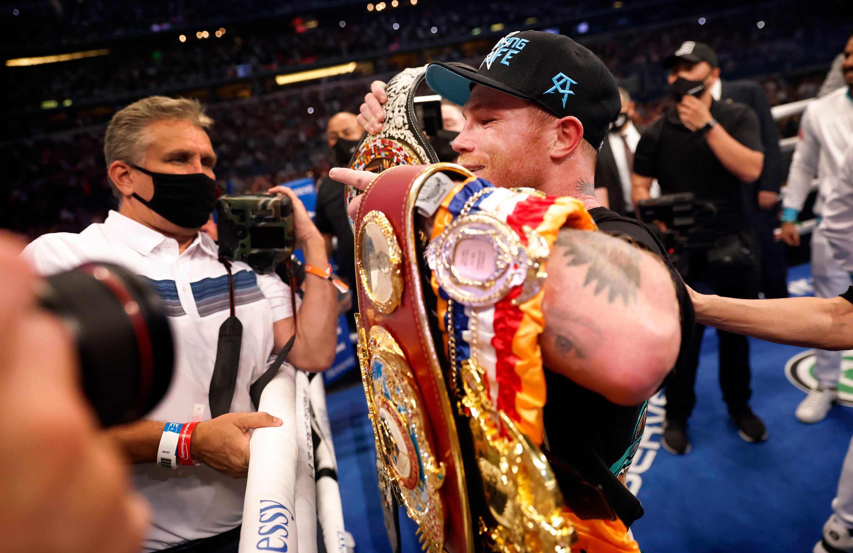 Boxers Canelo Alvarez celebrates with his new WBC belt and older belts after defeating Billy...