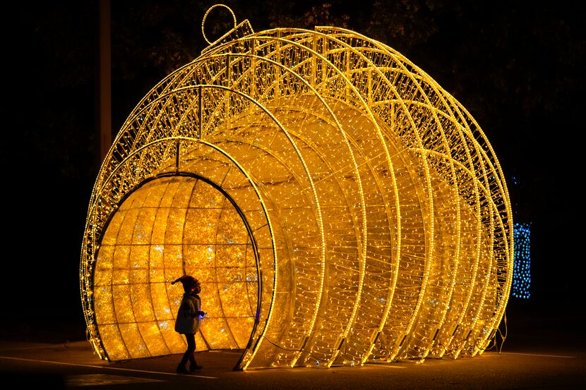 Gianna Gonzalez, 4, plays in a large display in the shape of a Christmas ornament in the...