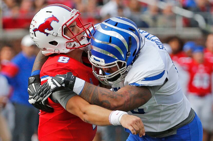 SMU quarterback Ben Hicks (8) is hit by Memphis safety Thomas Pickens (40) after he released...