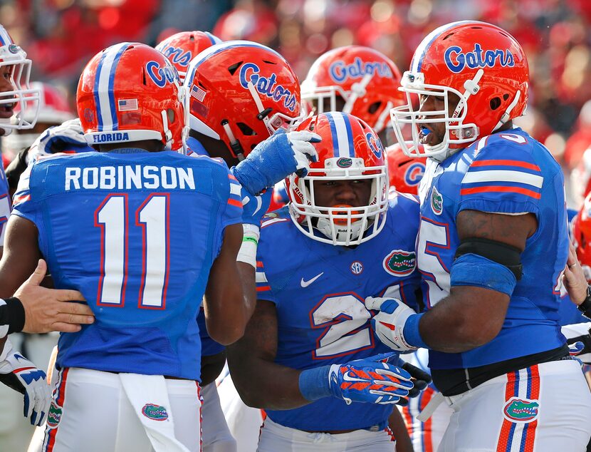 Florida running back Kelvin Taylor, center, celebrates a touchdown run with teammates...