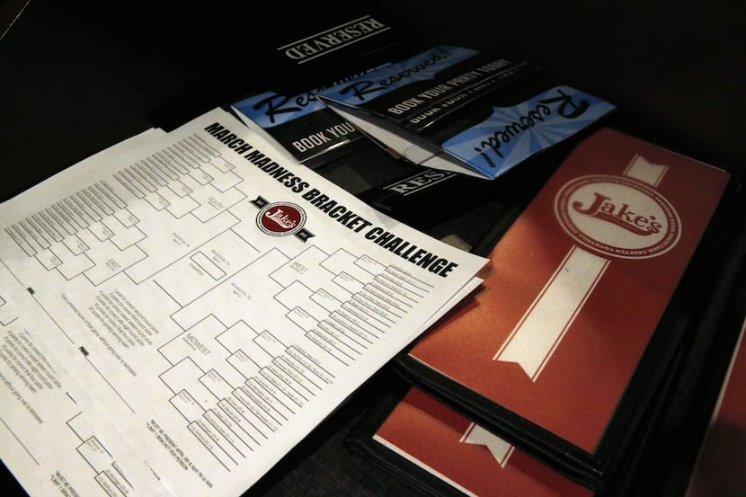 A stack of blank NCAA brackets sits with menus, available to patrons at Jake's sports bar,...