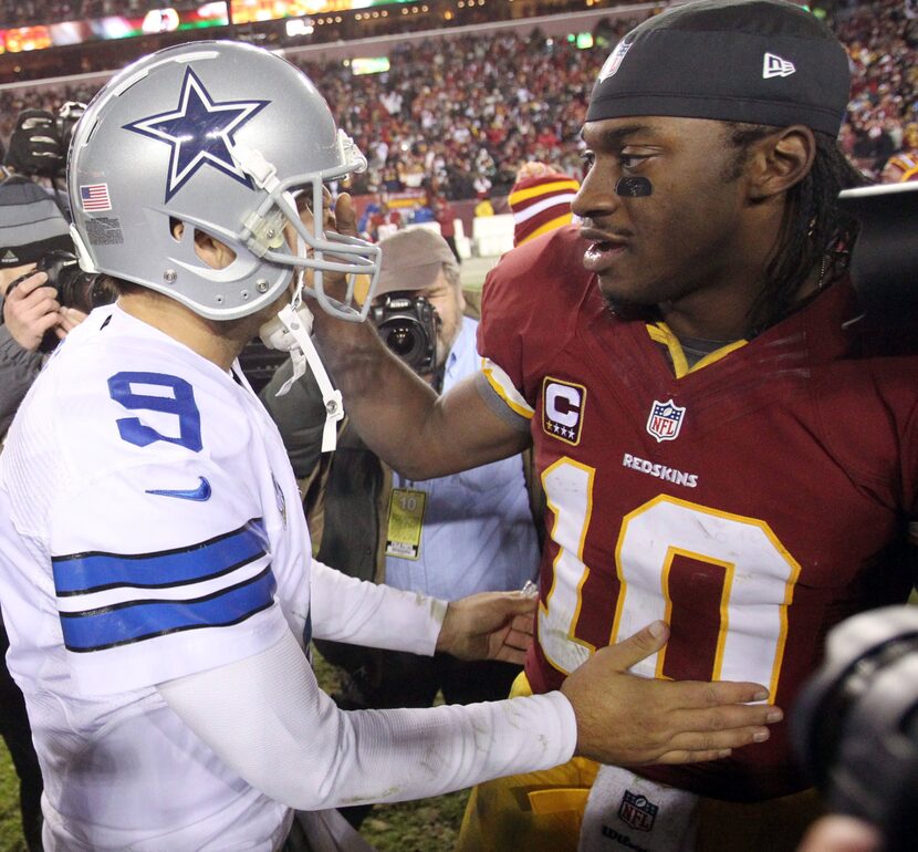 Dallas Cowboys quarterback Tony Romo (9) and Washington Redskins quarterback Robert Griffin...