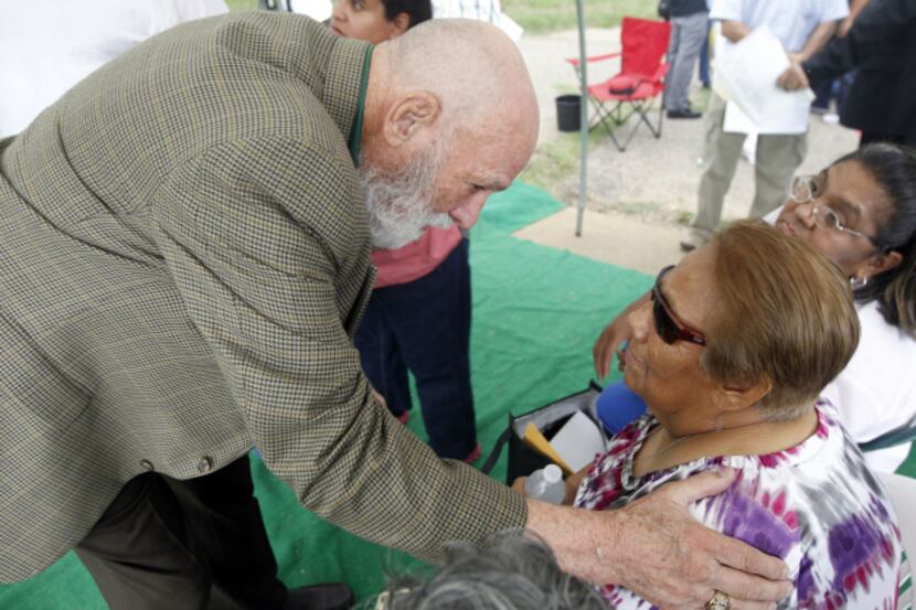 Retired Dallas police Officer Robert Rowe spoke with Bessie Rodriguez at a memorial at...