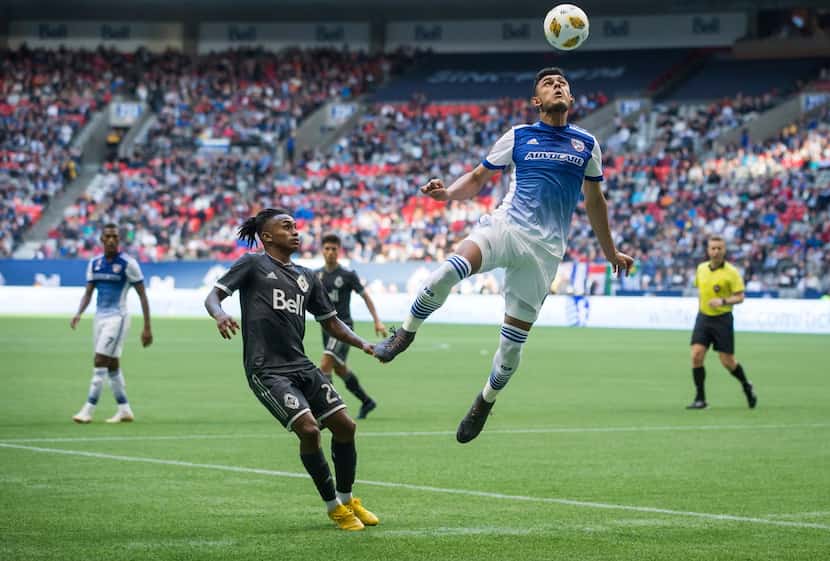 FC Dallas' Cristian Colman, front right, gets his head on the ball above Vancouver...