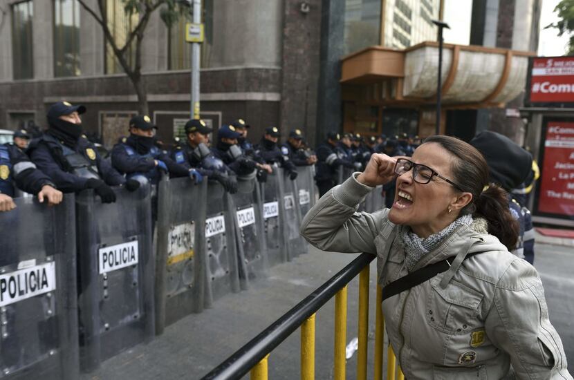 A demonstrator shouts slogans in front of the Senate building in Mexico City during a Dec....