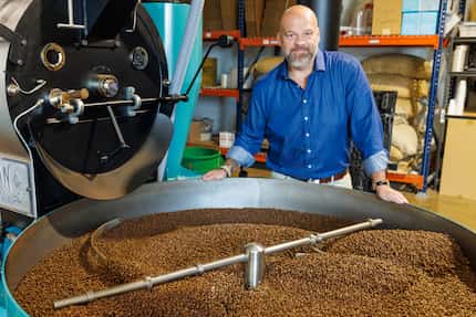 Founder and CEO Chris Parvin stands over freshly roasted coffee beans at White Rhino...