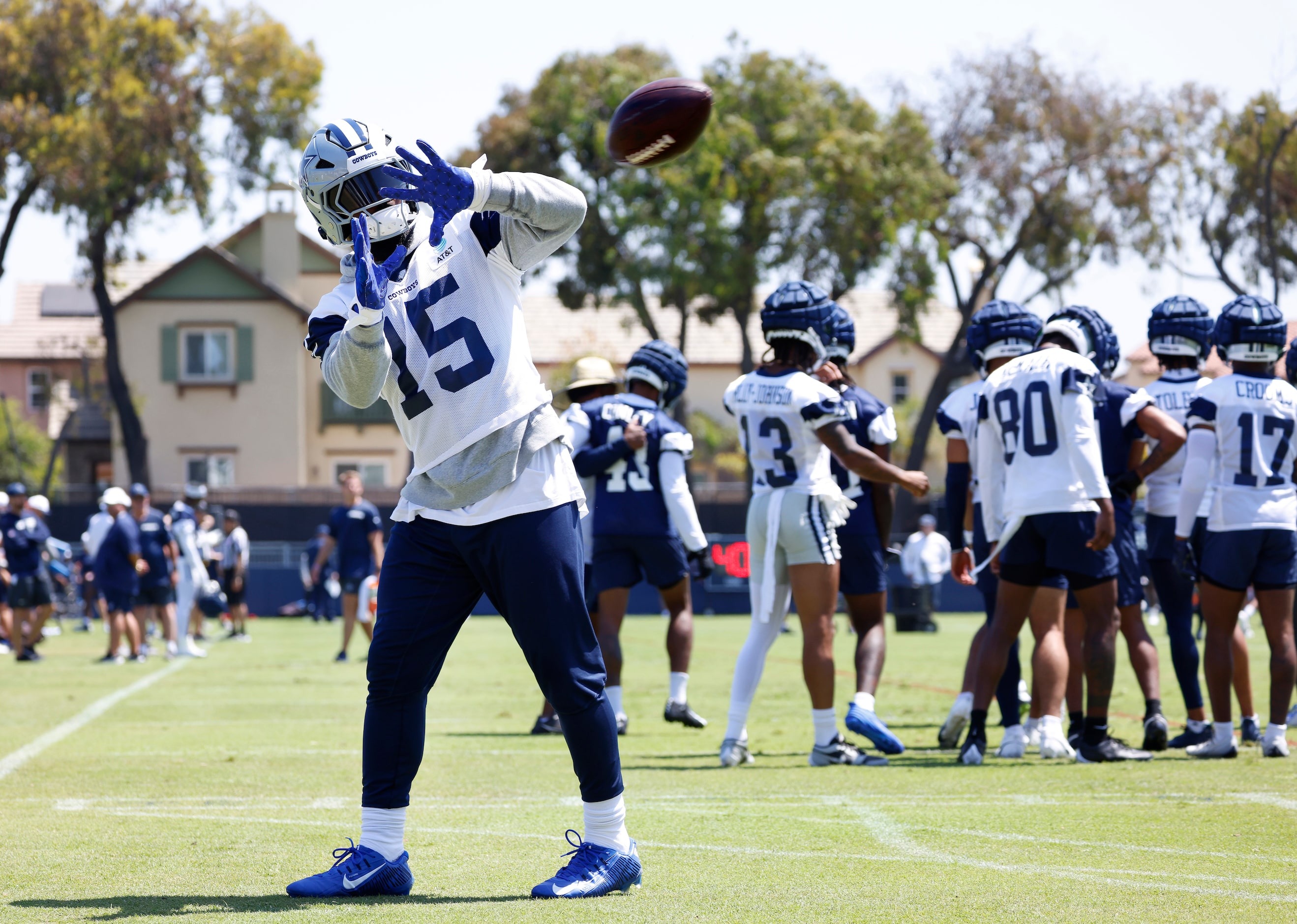 Dallas Cowboys running back Ezekiel Elliott (15) catches passes as he works out on the side...