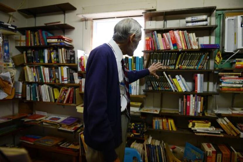 
Robert Jones stands among books of various languages in his shop, Imported Books, at 2025...