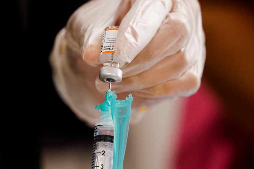 A COVID-19 Pfizer vaccine is prepared ahead of a news conference in May at Dallas County...
