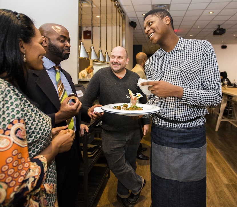 Intern Malik Runnels, right, of Pleasant Grove serves appetizers at Cafe Momentum in...