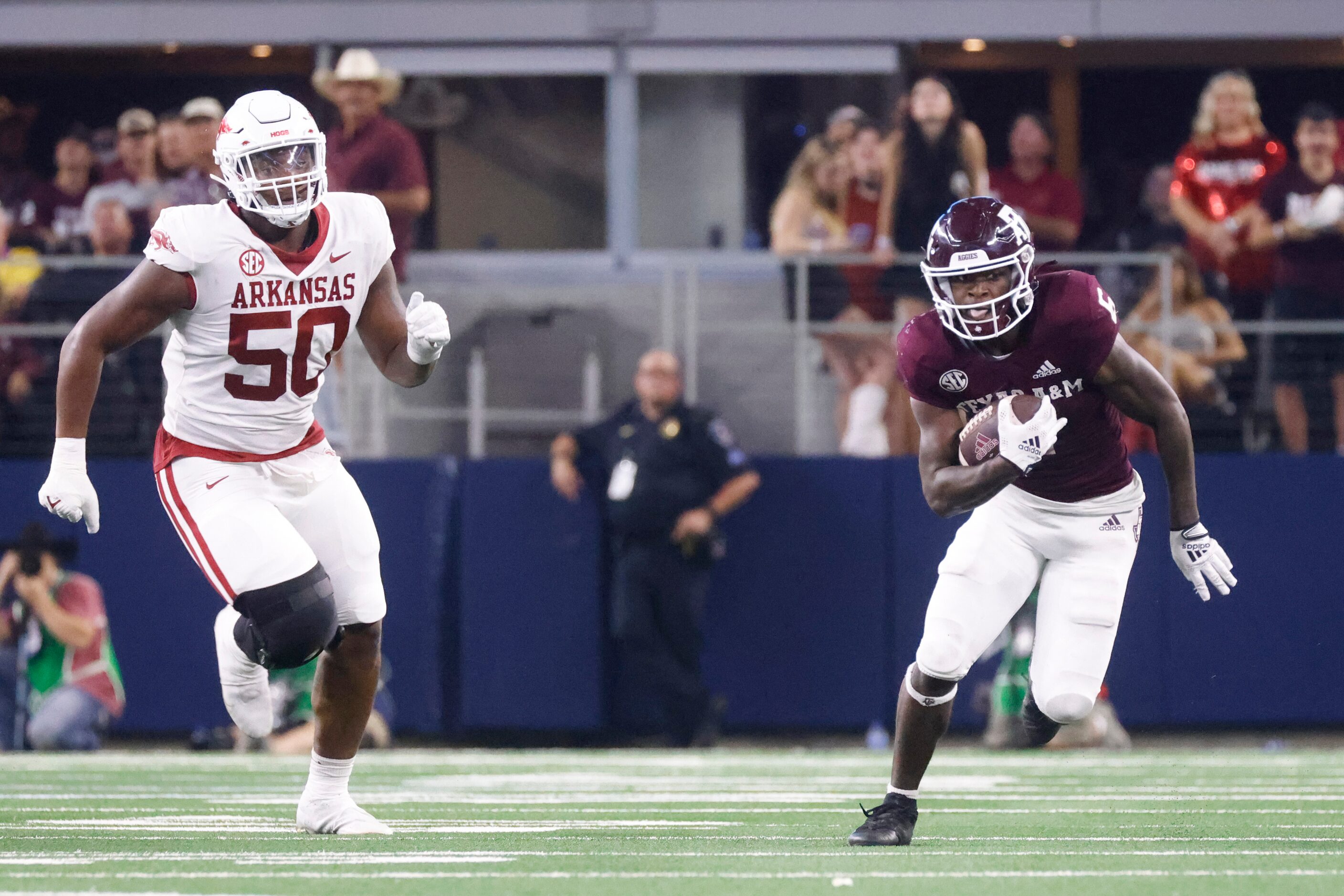 Texas A&M running back Devon Achane runs for a yardage past Arkansas defensive lineman Eric...