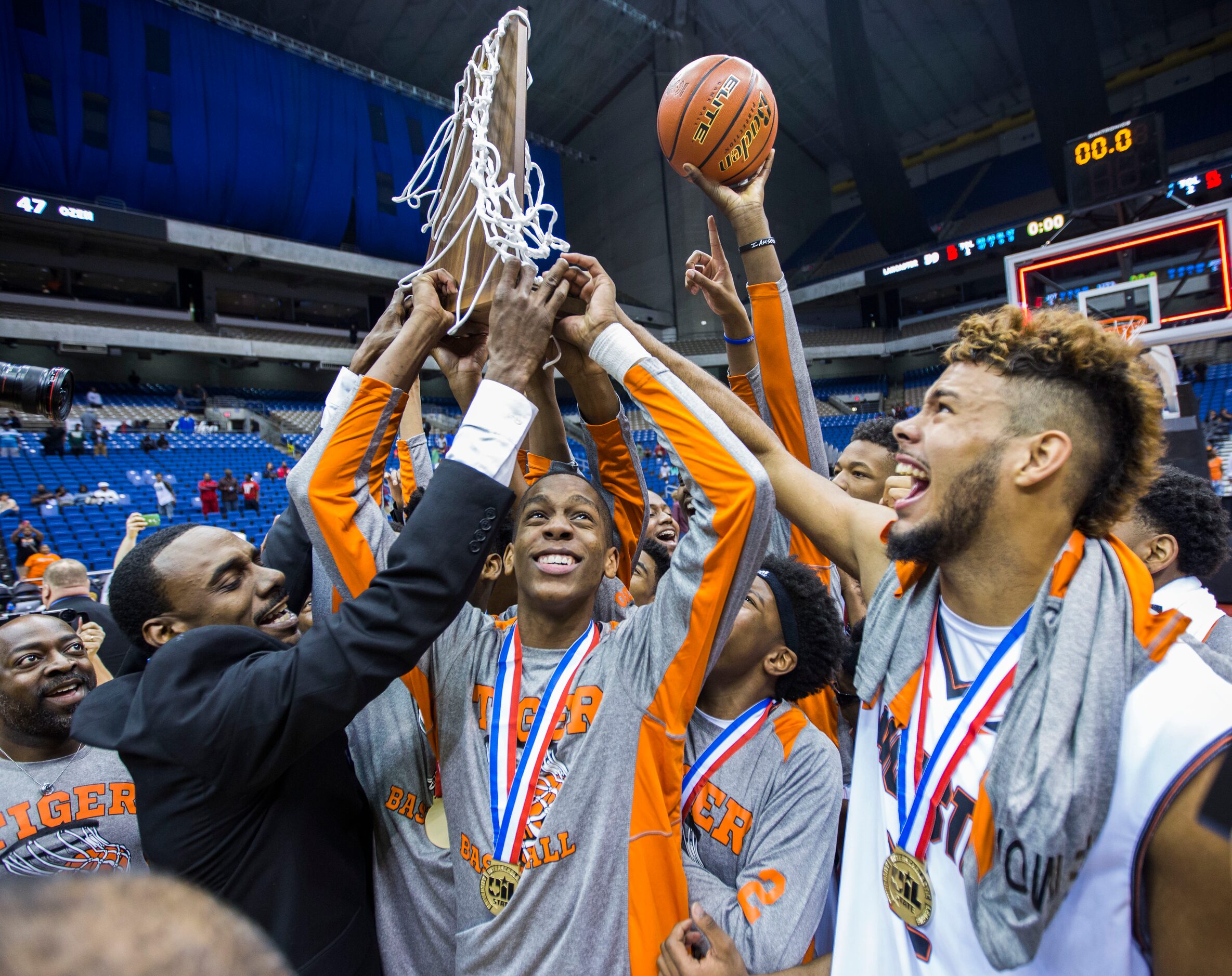 Lancaster head coach Ferrin Douglas and players celebrate a 59-47 win over Beaumont Ozen at...