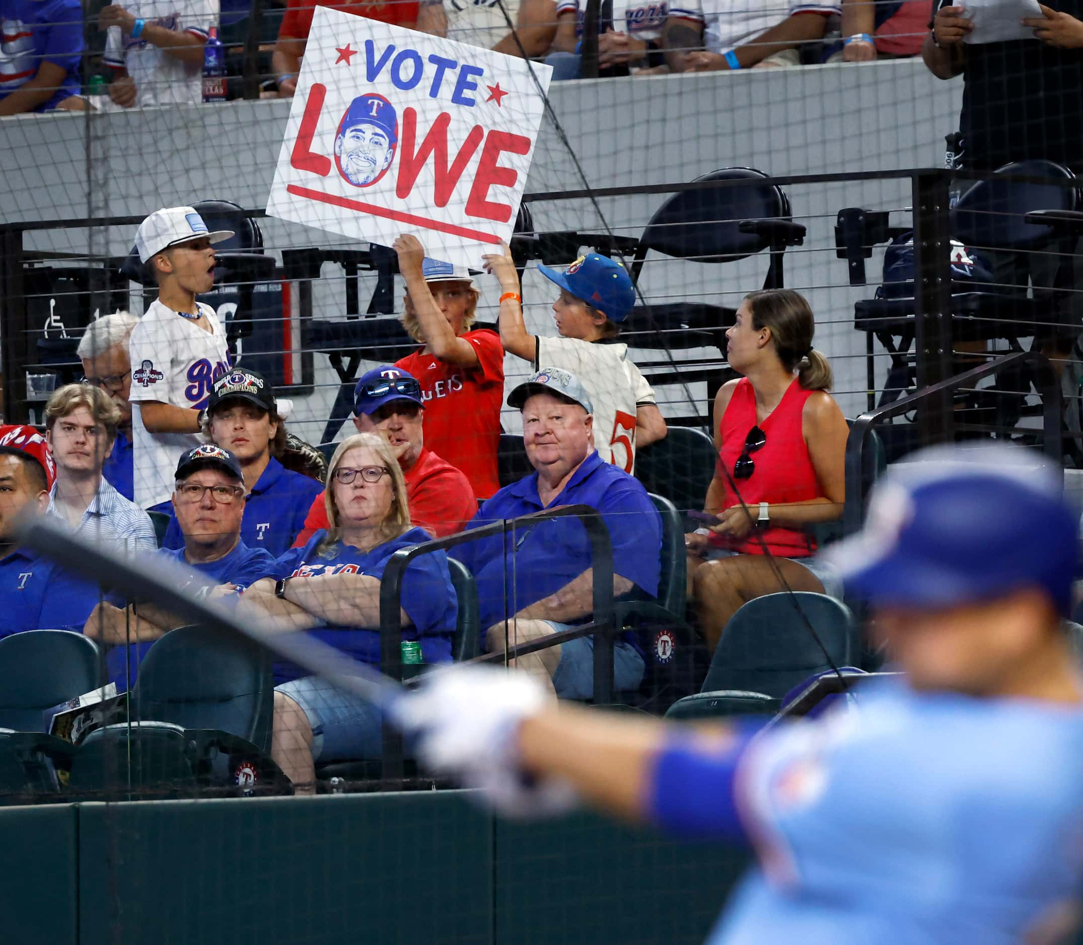 A young Texas Rangers fan shows his All-Star game support for batter Nathaniel Lowe...