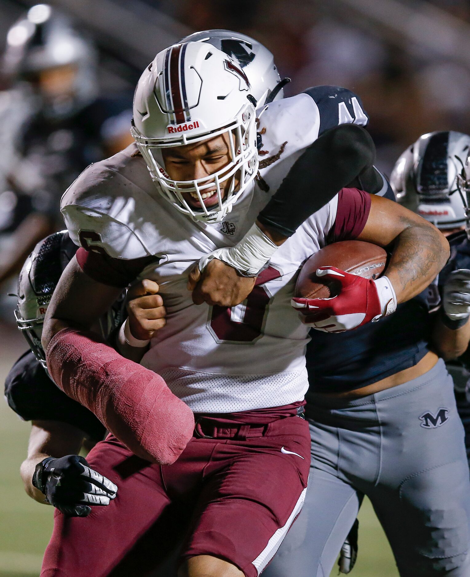 Lewisville senior running back Damien Martinez (6) battles Arlington Martin senior defensive...