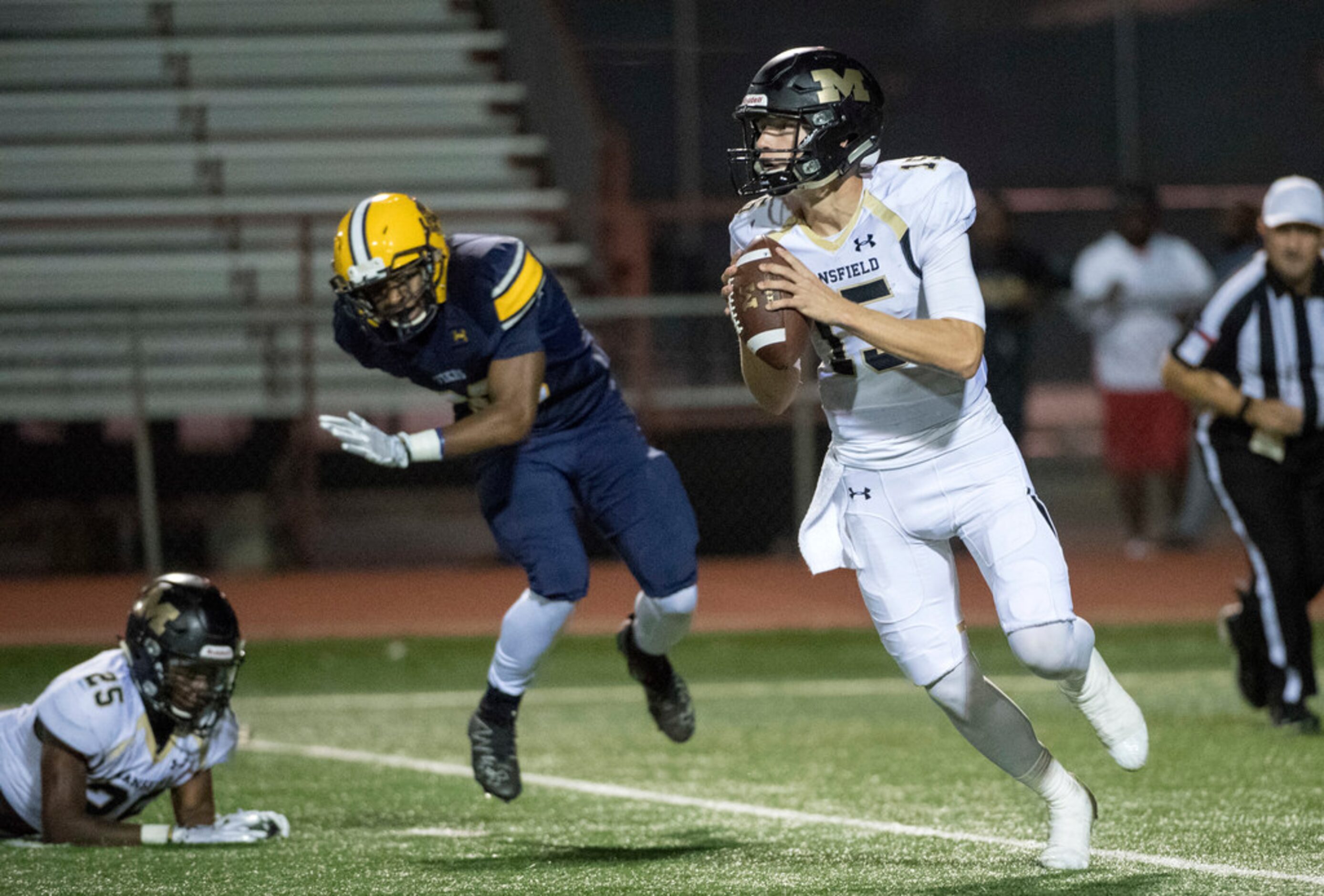 Mansfield senior quarterback Shawn Hartsfield (15) rolls out as Arlington Lamar senior...