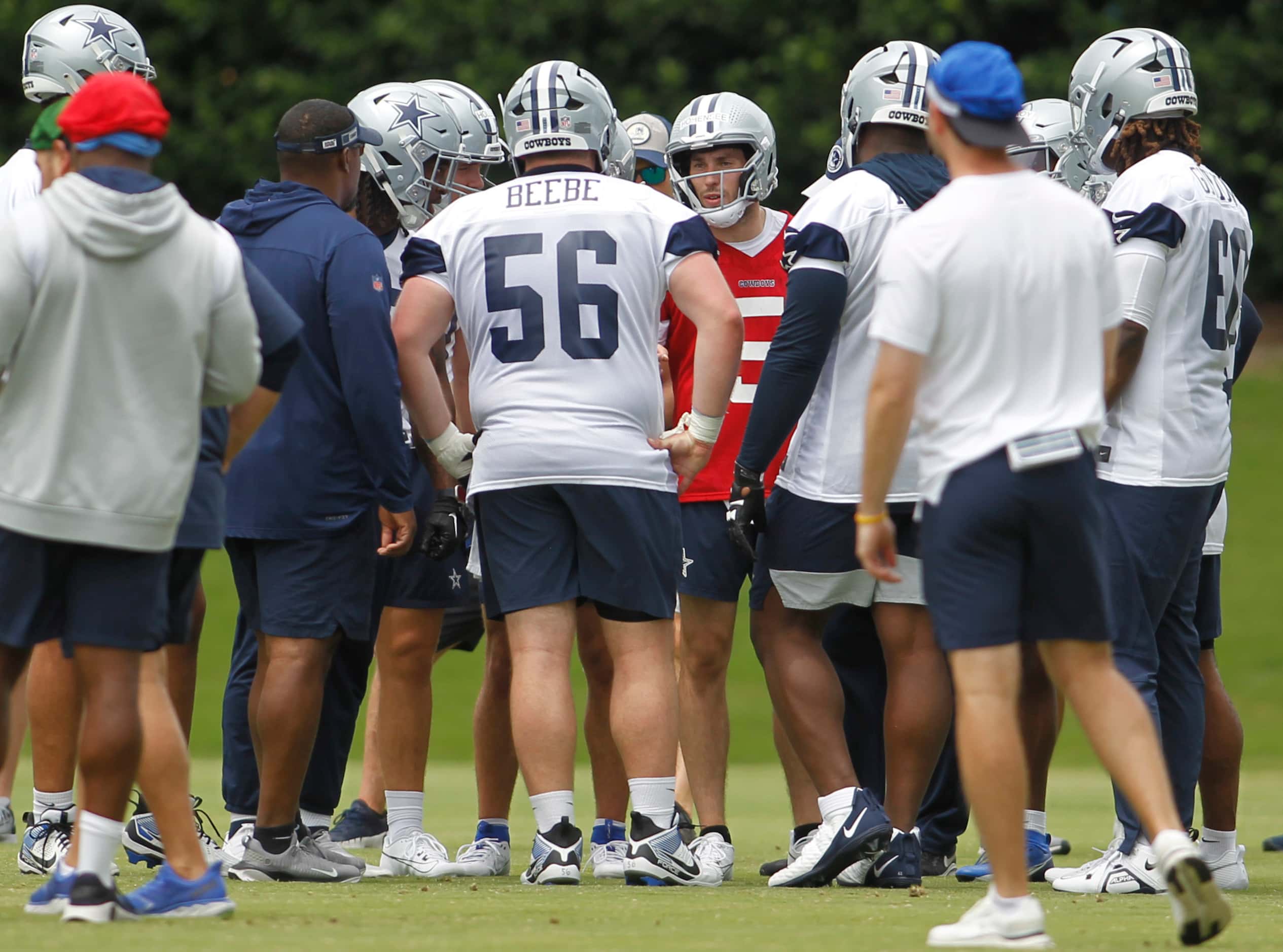 Dallas Cowboys quarterback Mike Hohensee (5), center background, discusses a play with the...