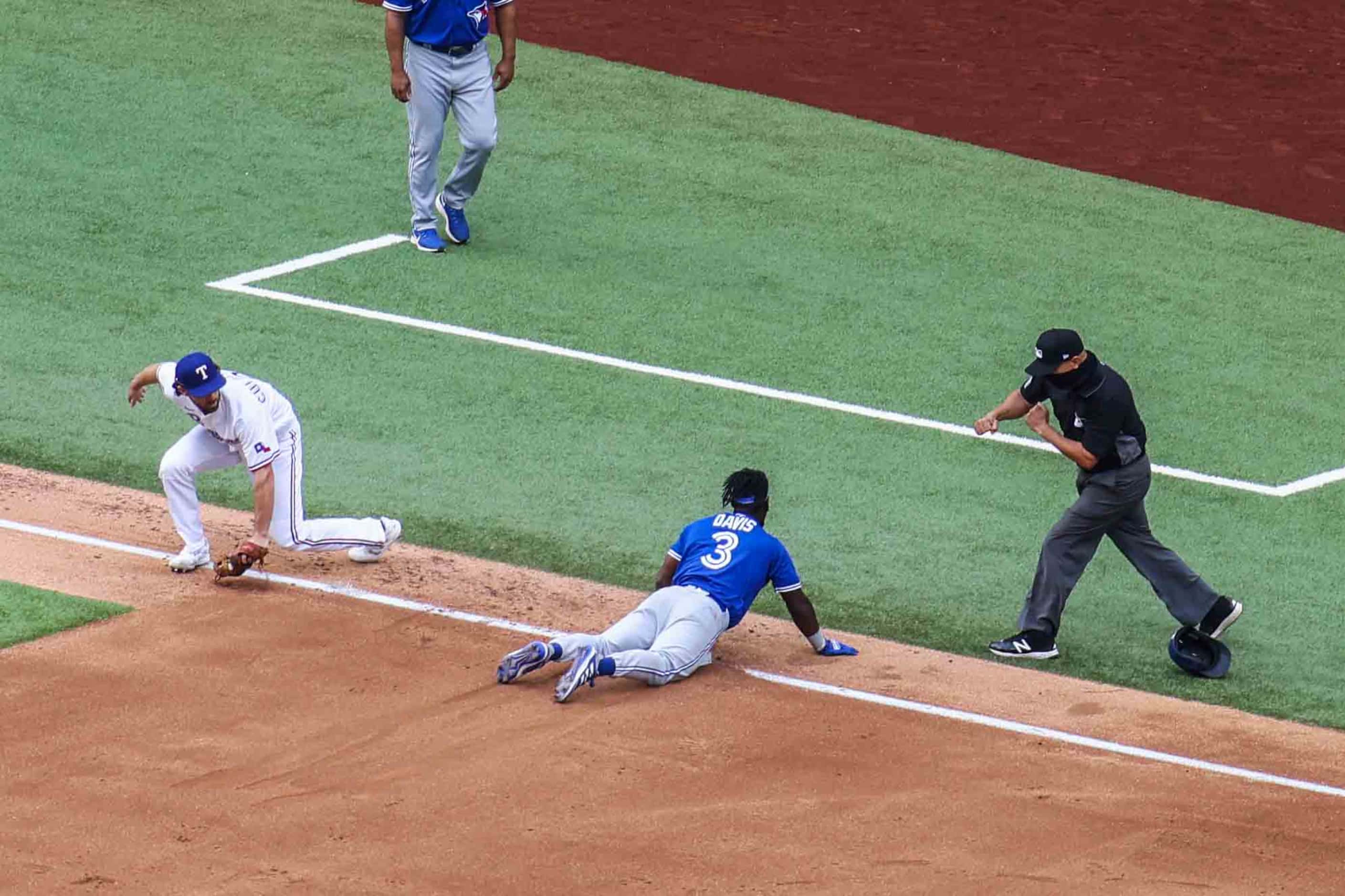 Toronto Blue Jays outfielder Jonathan Davis No. 3 gets tagged out by Texas Ranger infielder...