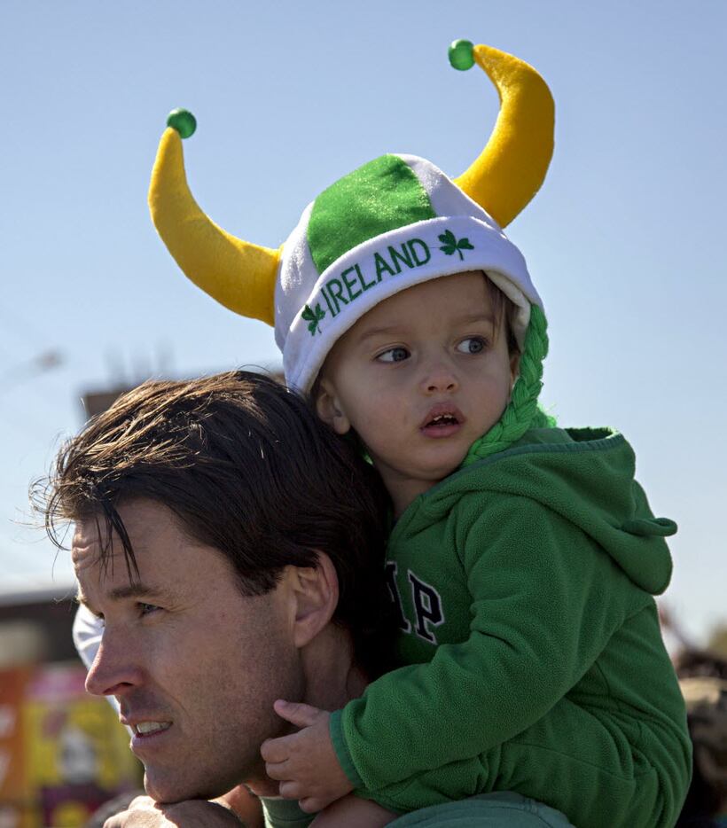 Greg Weldele of Flower Mound carries his 18-month-old son, Lorenzo, on his shoulders during...