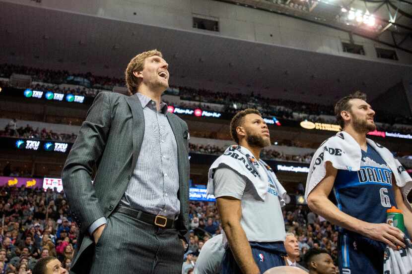 Injured Dallas Mavericks forward Dirk Nowitzki (41) watches a shot go up with guard Justin...