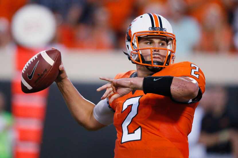Oklahoma State quarterback Mason Rudolph (2) passes during the first half of an NCAA college...