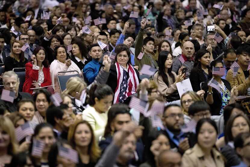 Una multitud ondea banderas norteamericanas durante una ceremonia de ciudadanía en Los...