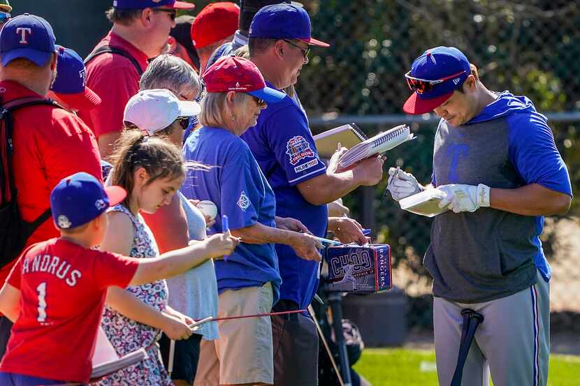 Texas Rangers outfielder Shin-Soo Choo signs autographs during a spring training workout at...