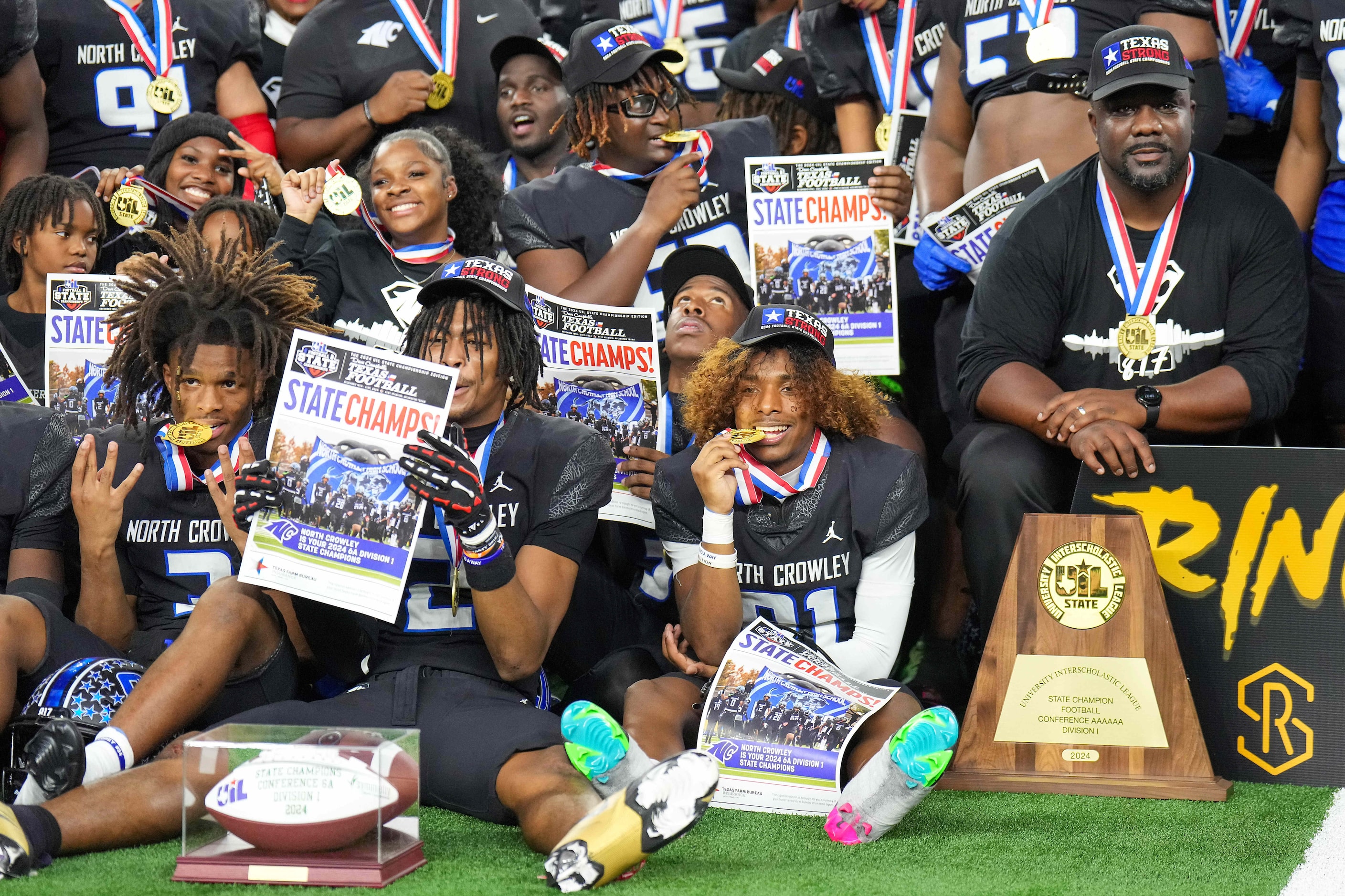 North Crowley head coach Ray Gates poses with his players after a victory over Austin...