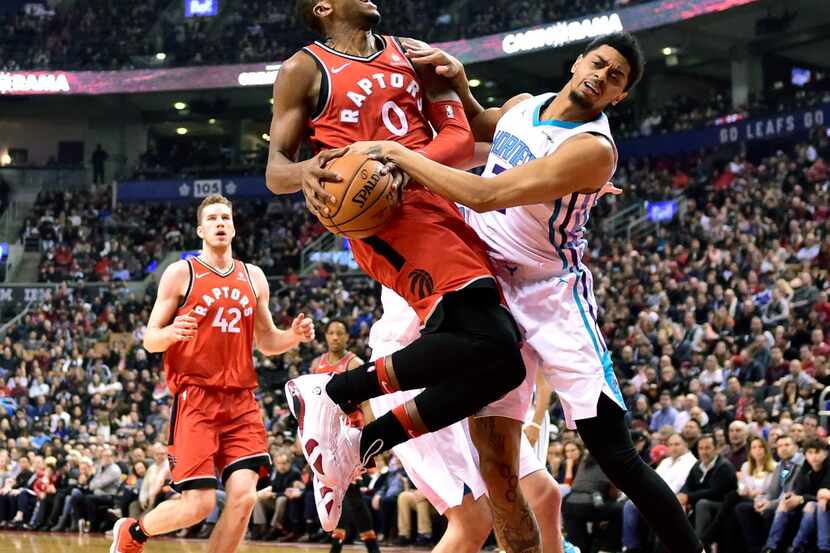Toronto Raptors forward C.J. Miles (0) collides with Charlotte Hornets guard Jeremy Lamb on...