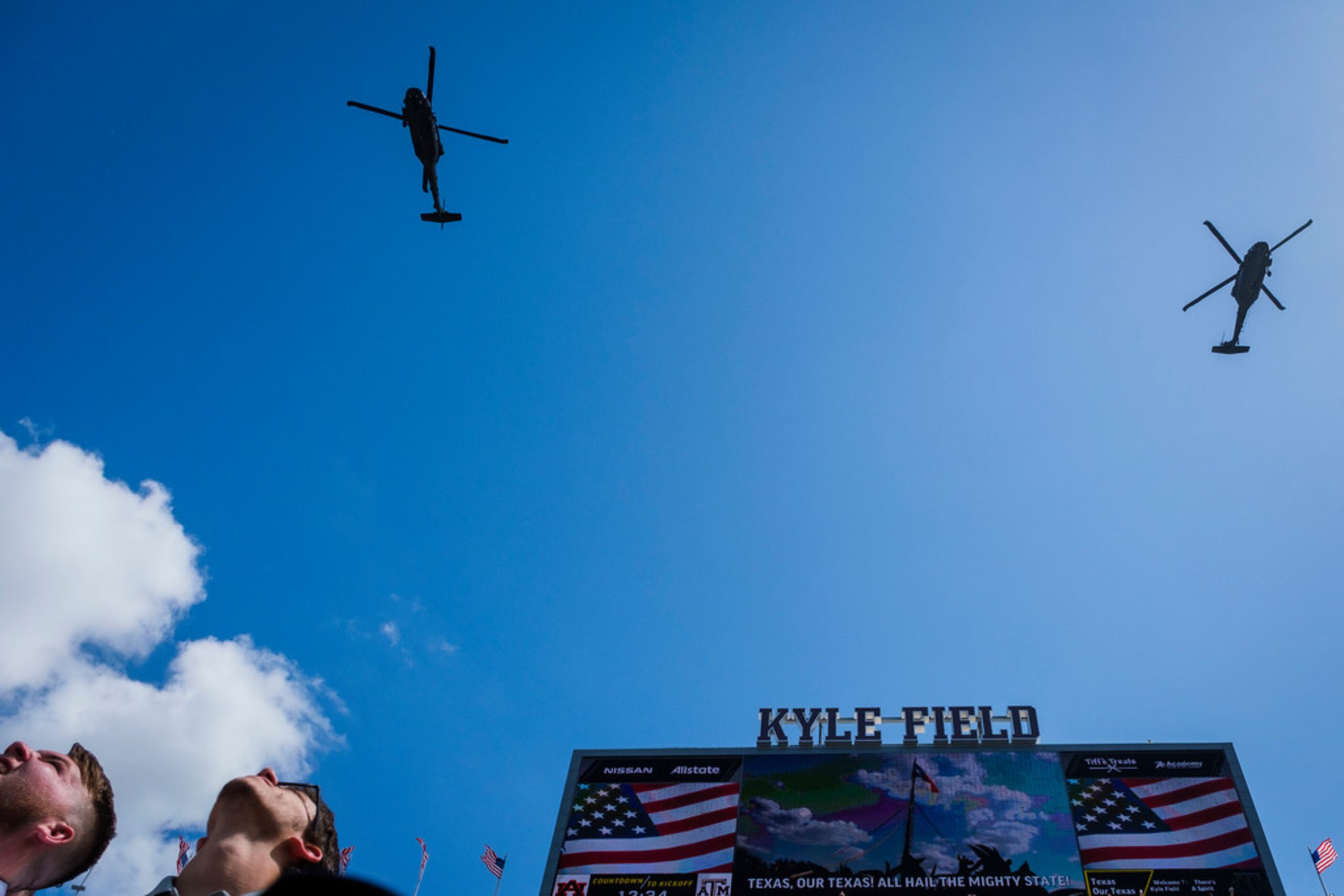 Military helicopters perform a flyover before an NCAA football game between the Texas A&M...