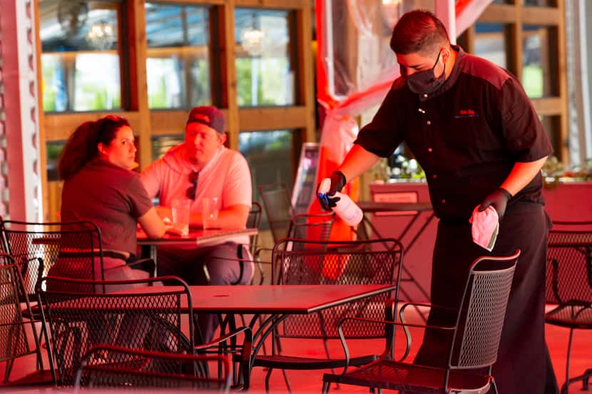 A restaurant worker cleans a table at Beto & Son at Trinity Groves in Dallas. Nationwide,...
