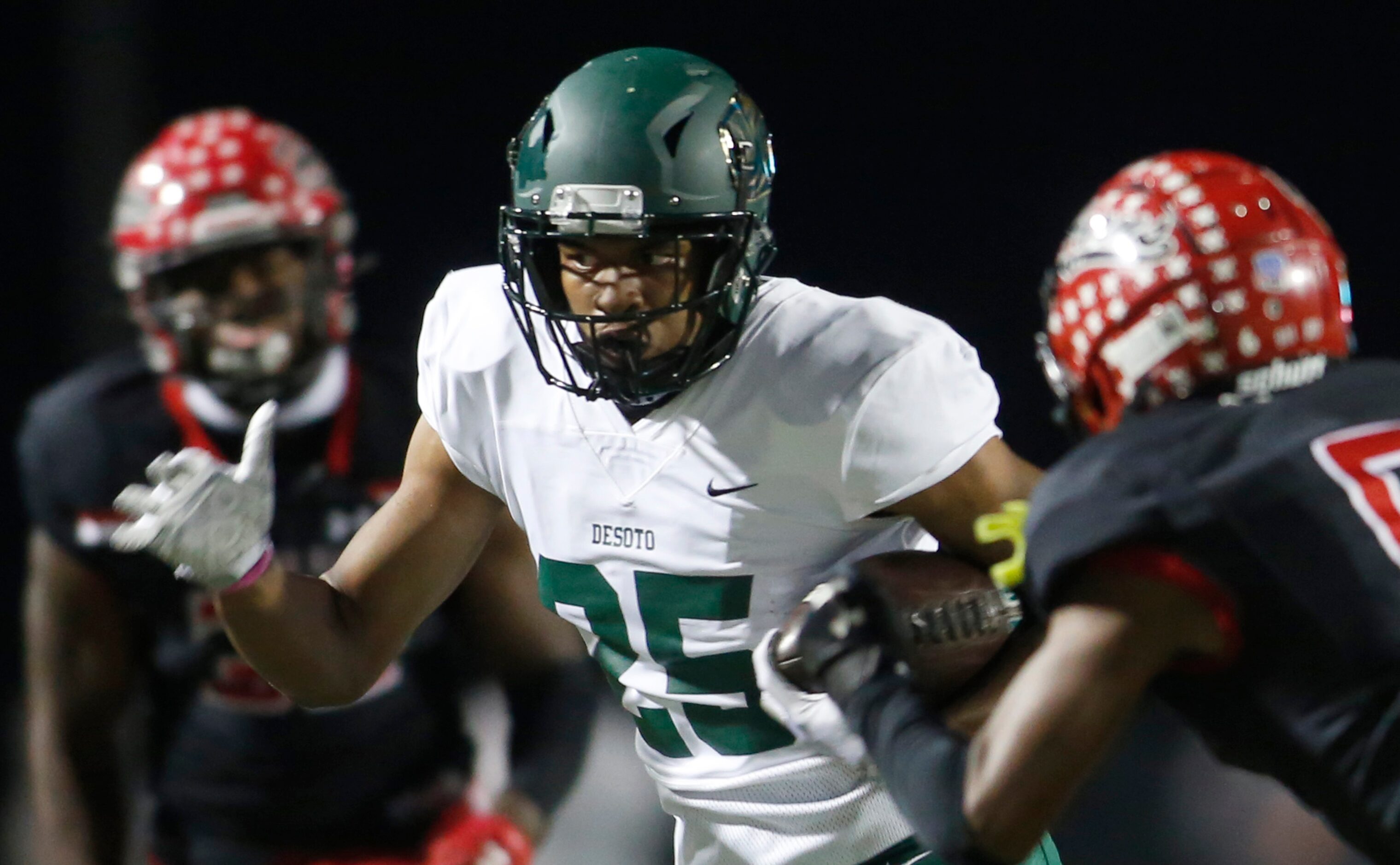 DeSoto running back Brendan White (25) splits the defense of a pair of Cedar Hill defenders...