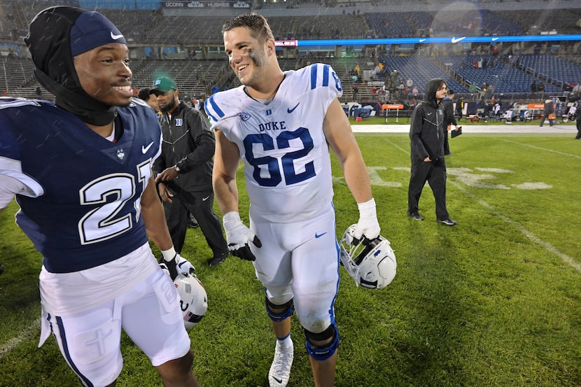 Connecticut defensive back Lee Molette III (21) and Duke offensive lineman Graham Barton...