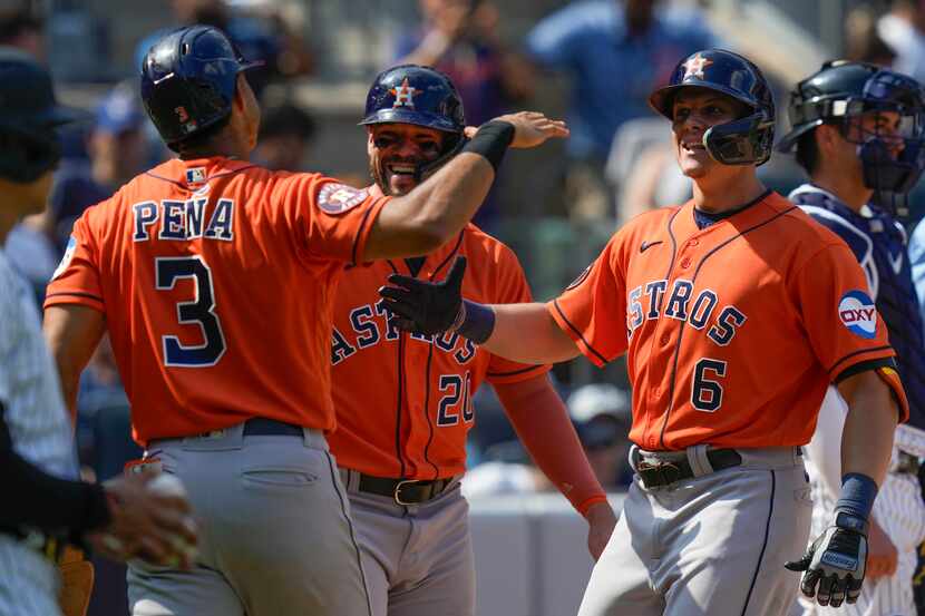 Houston Astros' Jake Meyers (6) is greeted by Jeremy Pena (3) and Chas McCormick (20) after...