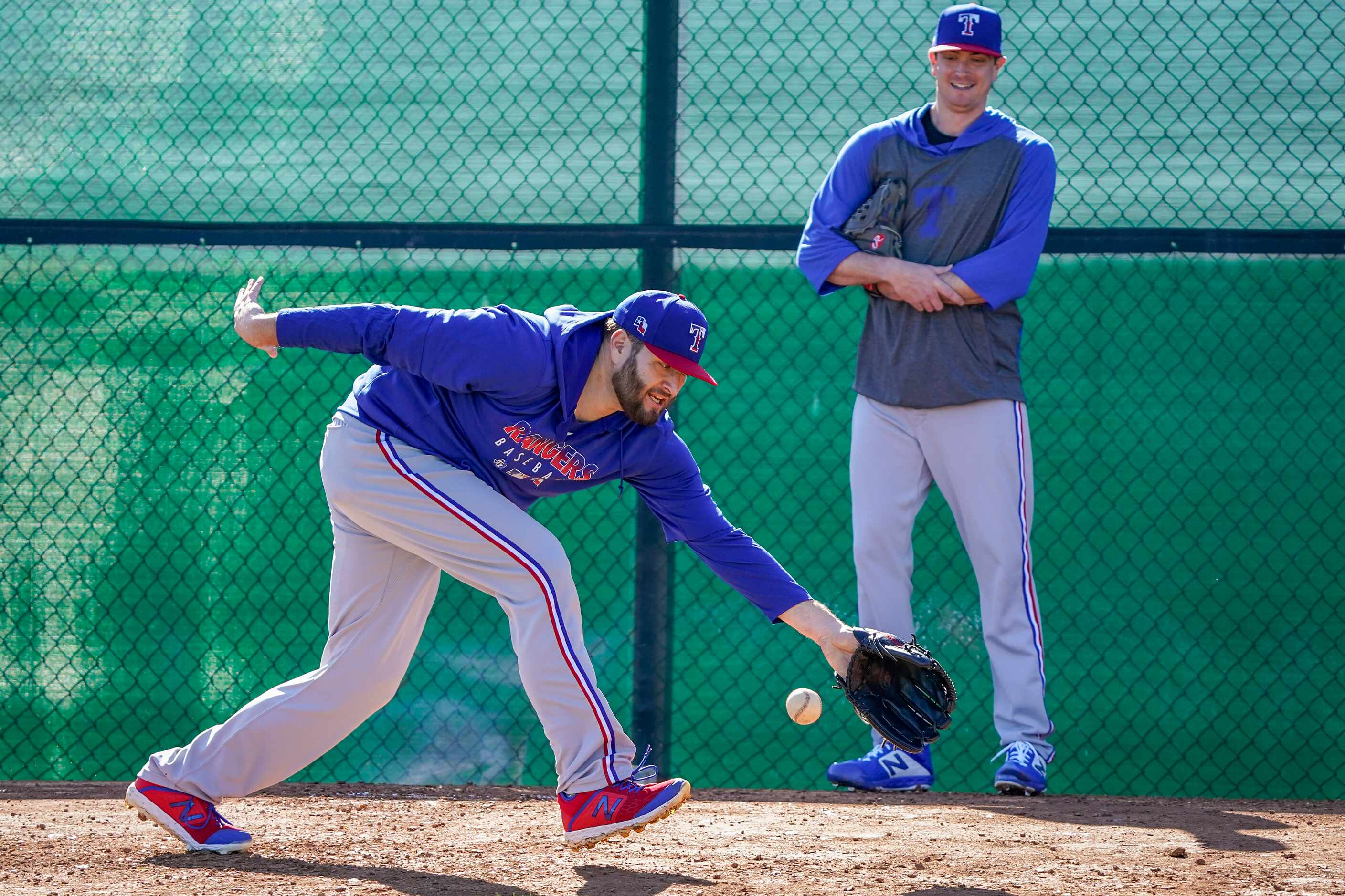 Texas Rangers pitcher Lance Lynn participates in a fielding drill as pitcher Kyle Gibson...