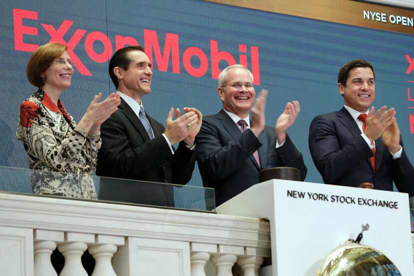 Exxon Mobil Corporation Chairman & CEO Darren Woods, third from left, joins the applause...