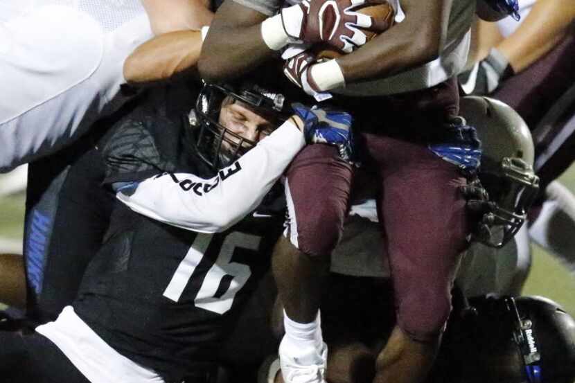 Plano High School running back Kyron Cumby (2) is stopped at the line of scrimmage by Hebron...