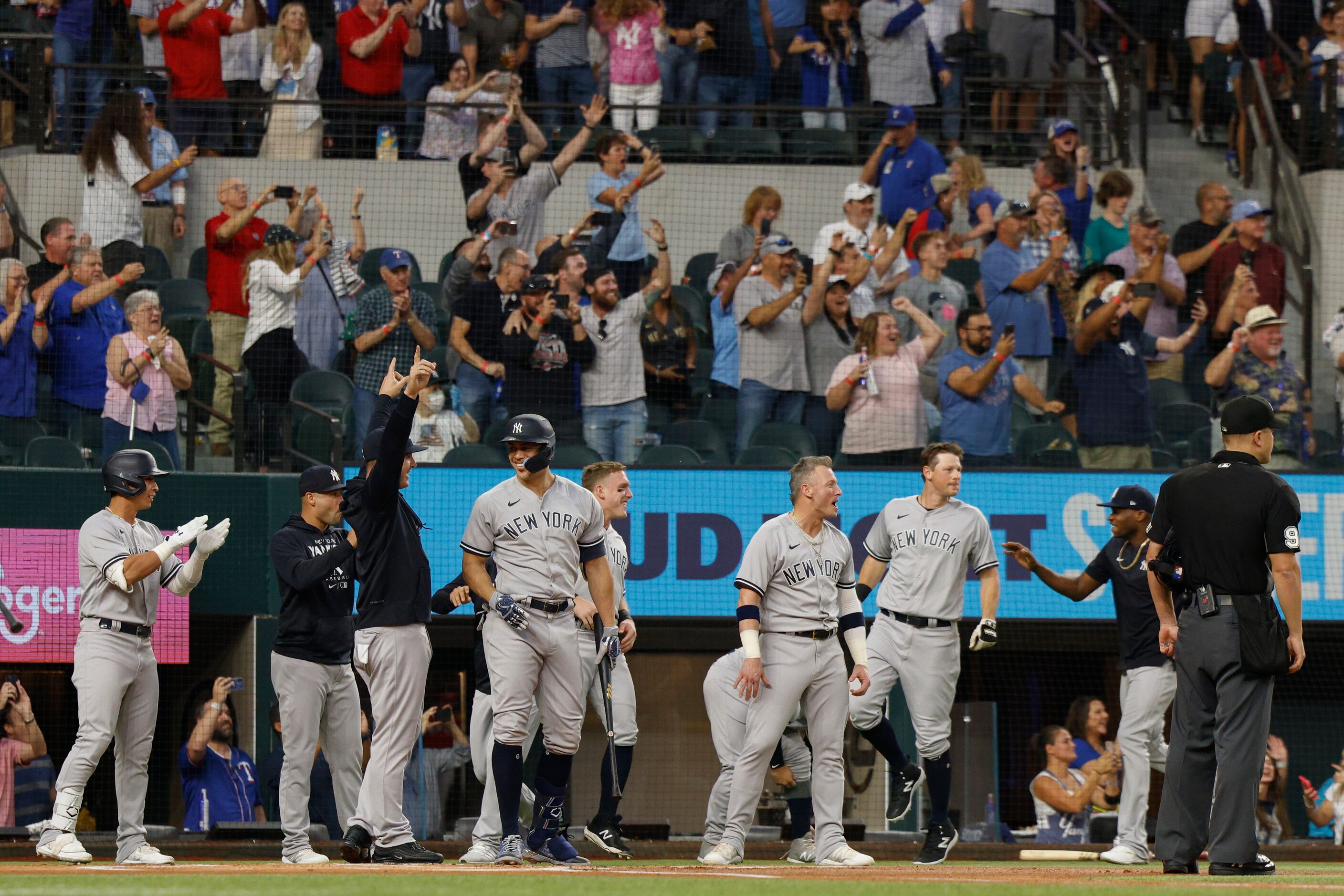 New York Yankees players wait for right fielder Aaron Judge at home plate after he hit his...