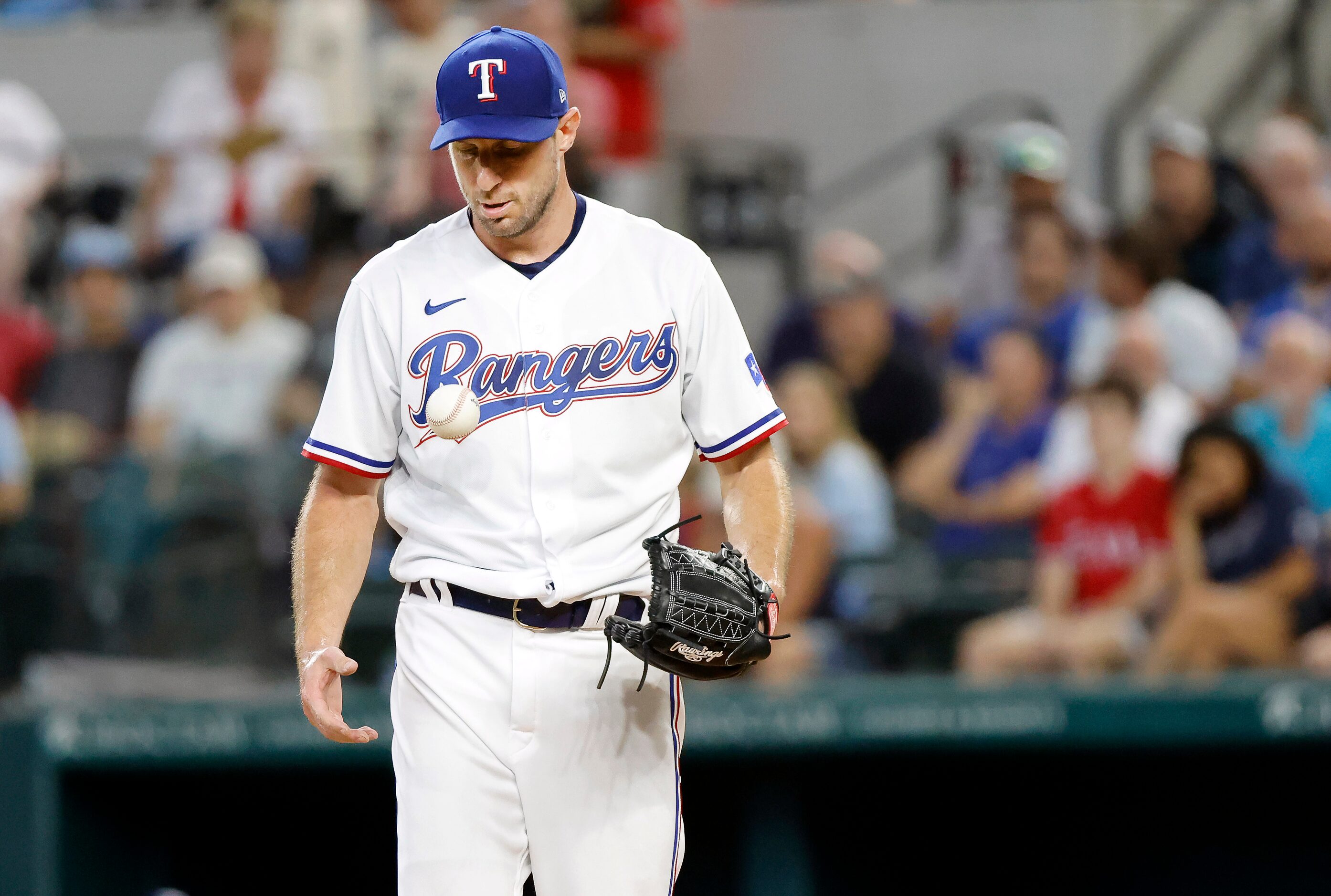 Texas Rangers starting pitcher Max Scherzer (31) flips the ball to this hand before throwing...