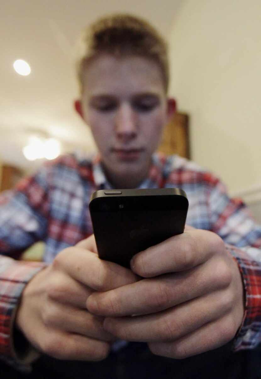 Mark Risinger, 16, checks his smartphone at home in Glenview, Ill.